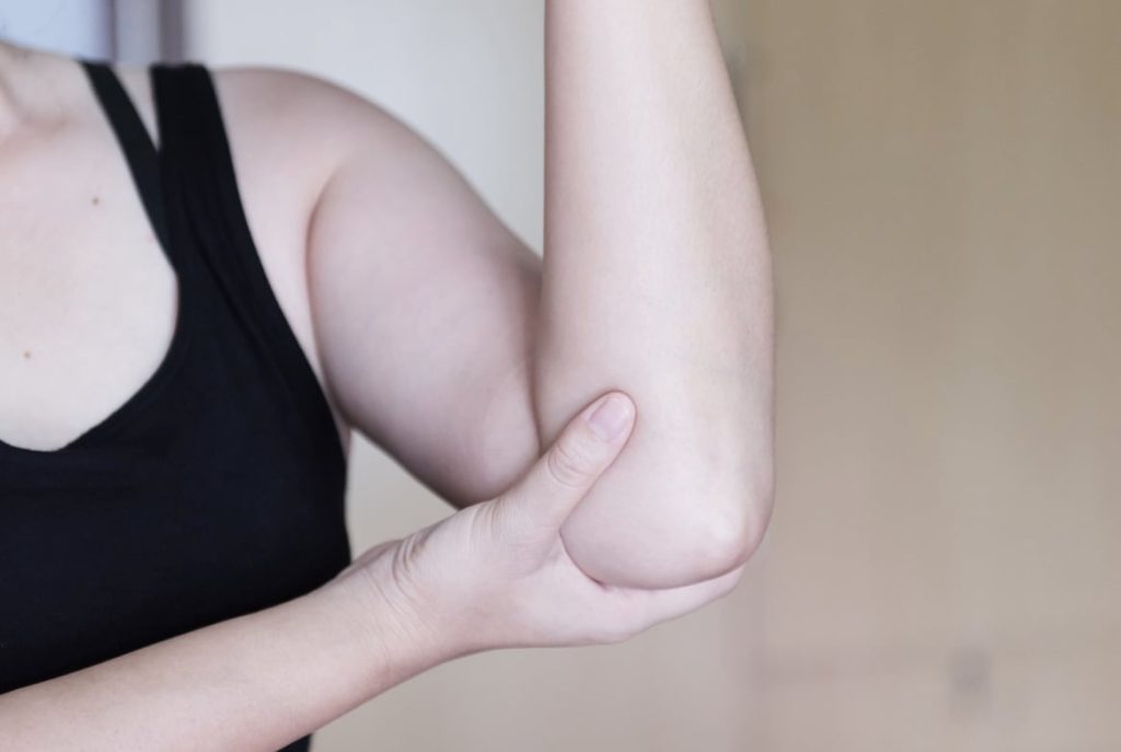 A woman grabs their lower arm.